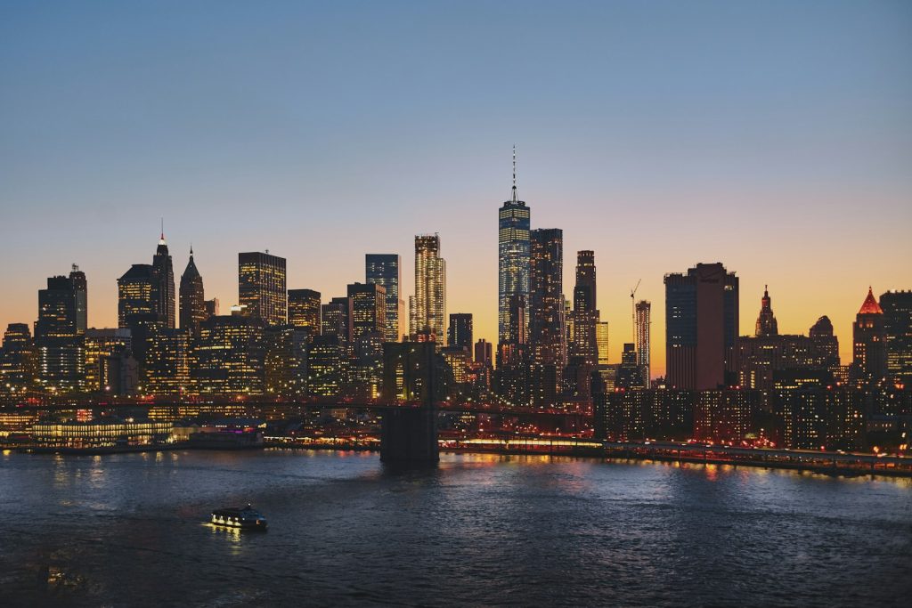 A city skyline and bridge lit up at dusk