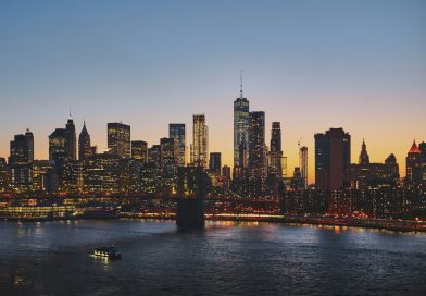 A city skyline and bridge lit up at dusk