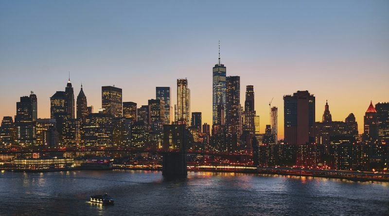 A city skyline and bridge lit up at dusk