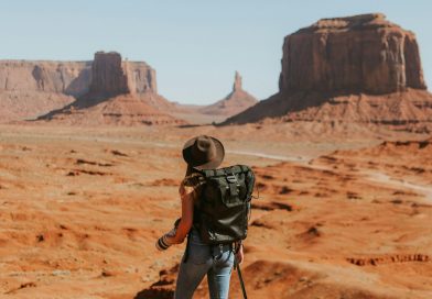 A solo traveler with a backpack looking out over a desert landscape