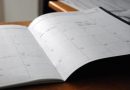 An open monthly planner on a wooden desk