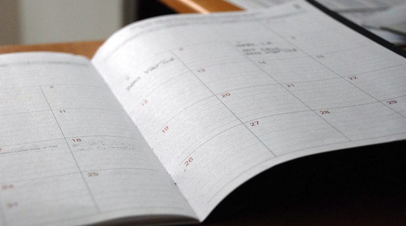 An open monthly planner on a wooden desk