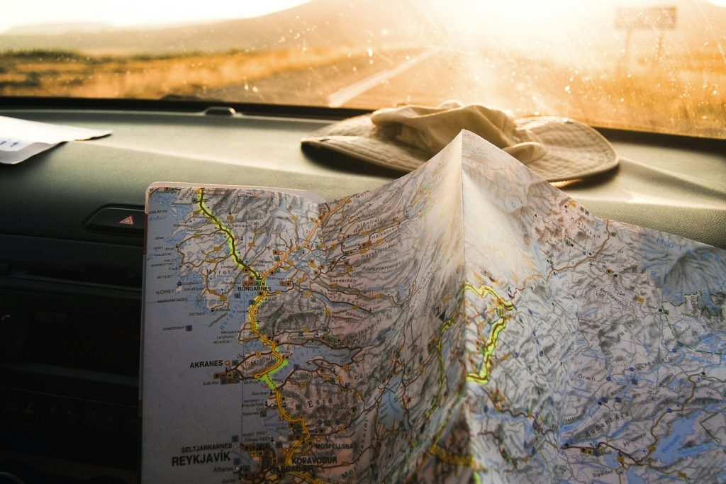 A traveler holding an open map in warm sunlight