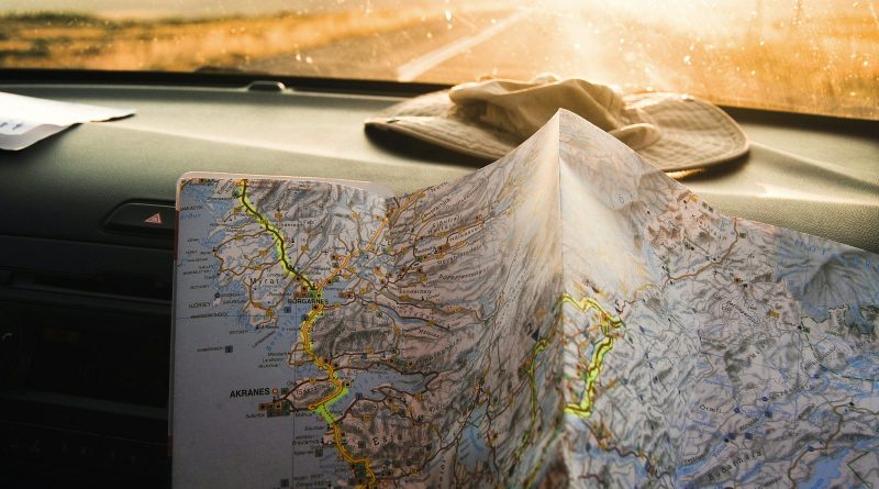 A traveler holding an open map in warm sunlight